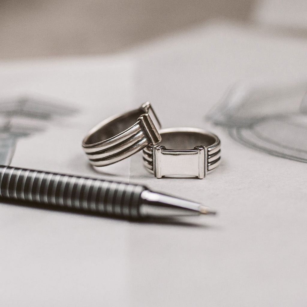 A pair of silver rings on a piece of paper.