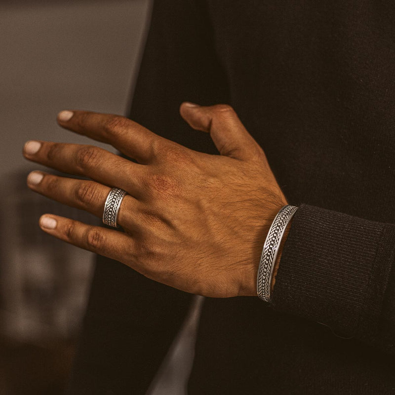 Ein Mann trägt den Fariq Ring aus oxidiertem 925er Silber und ein Herrenarmband von NineTwoFive.