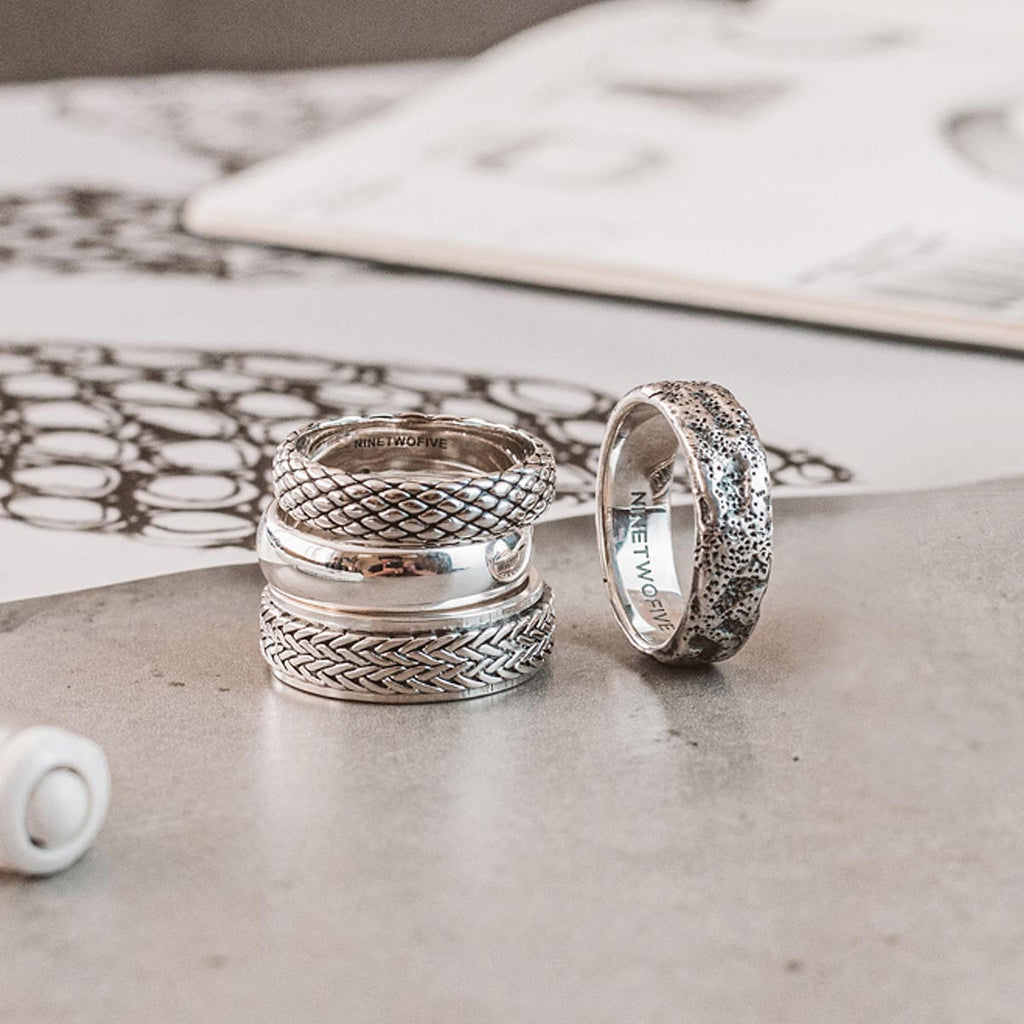 Zwei silberne Ringe auf einem Tisch.
