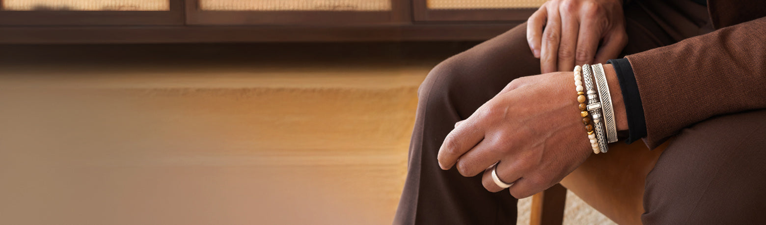 Close up of man wearing a mens silver rings, bangles and beaded bracelets from Ninetwofive.