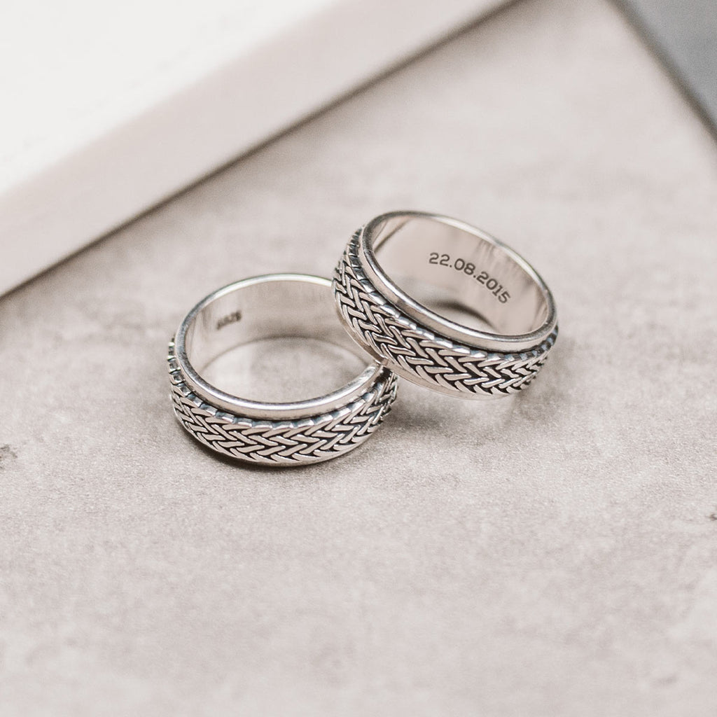 Zwei silberne Ringe auf einem Tisch.