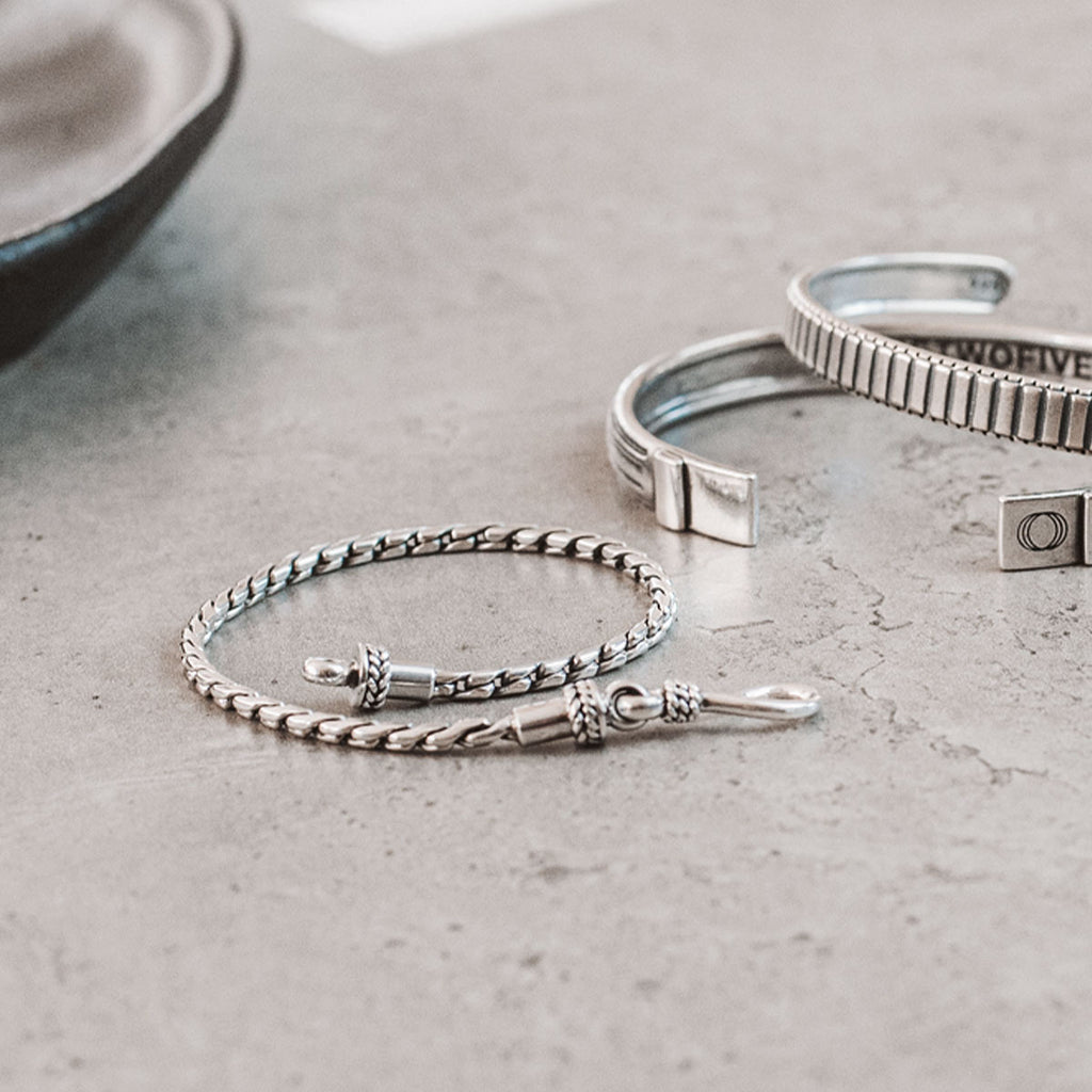 A pair of silver bracelets on a table.