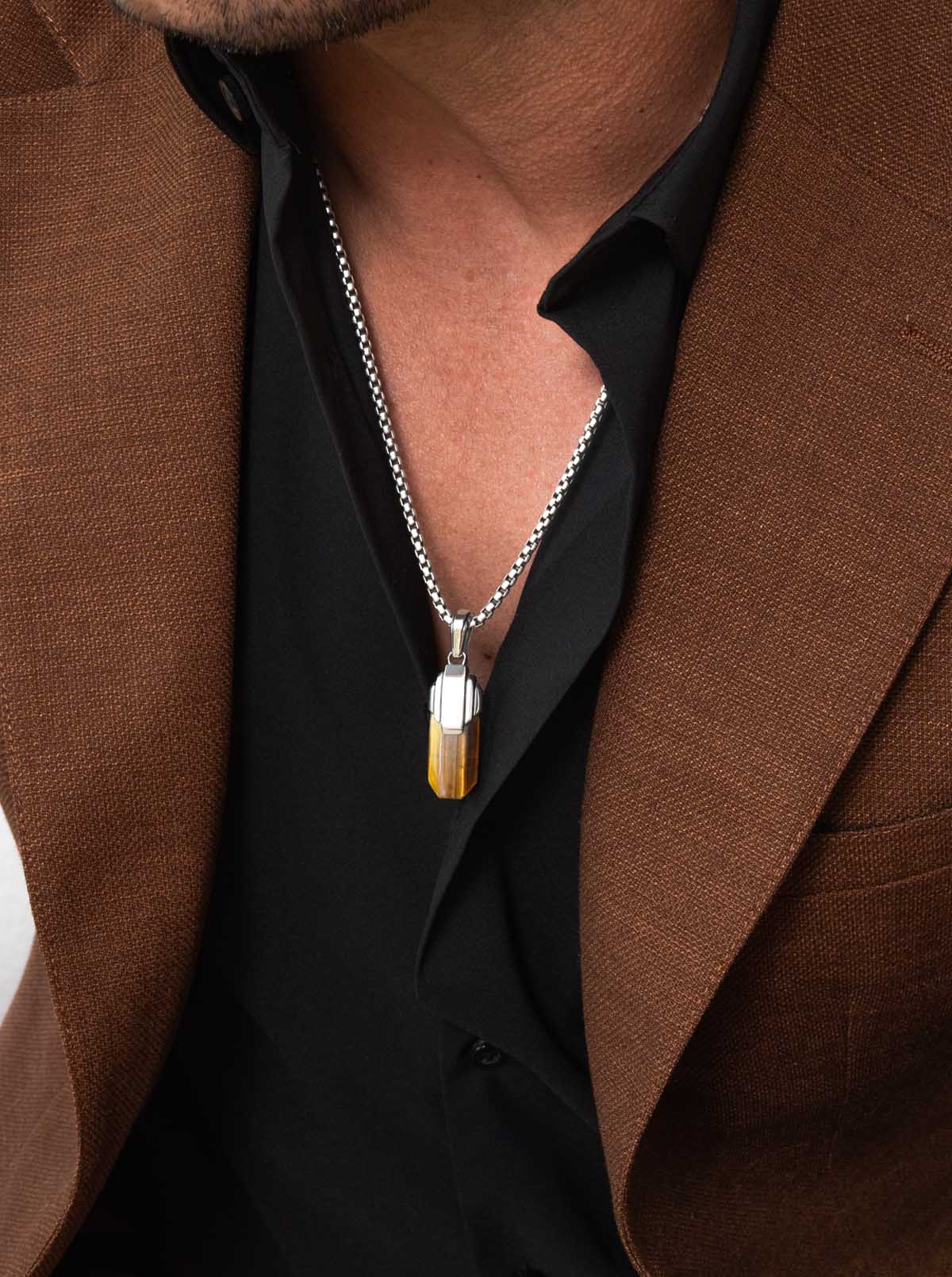 gentleman wearing a silver chain with a tiger eye pendant