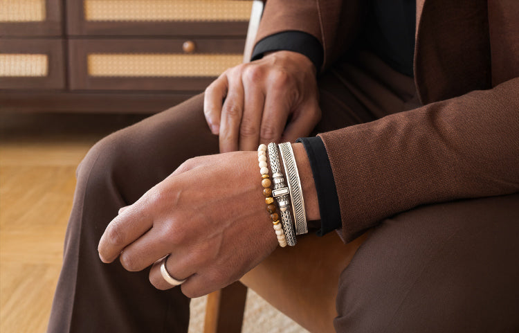 closeup shot of a gentleman wearing a silver bracelet a silver bangle and a free beaded bracelet from the ninetwofive mens jewellery collection