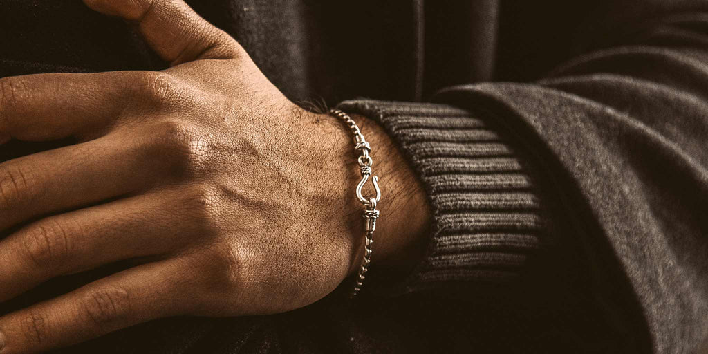A man's wrist with a bracelet on it.