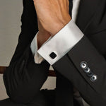 Man in een zwart pak draagt Nael 925 zilveren Black Onyx heren manchetknopen op zijn overhemd van Ninetwofive.