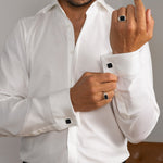 Model in een wit overhemd draagt Nael heren manchetknopen Black Onyx zilver en een ring van Ninetwofive.
