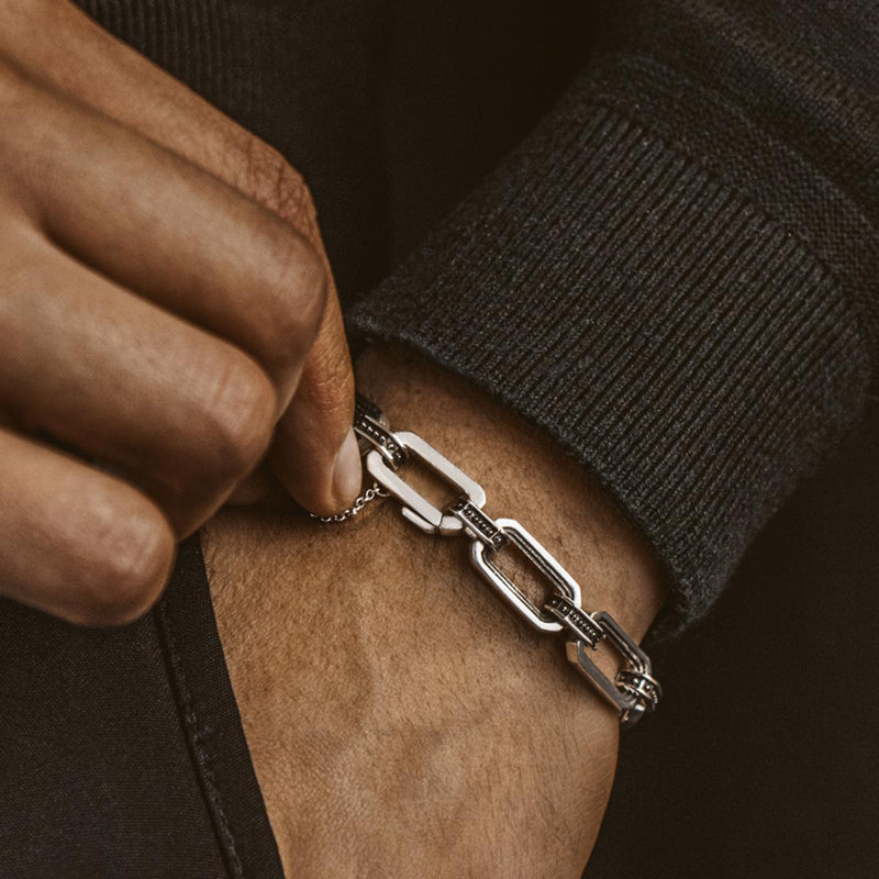 Close-up van een stevige 925 sterling zilveren schakelarmband voor heren van Ninetwofive, waarbij het gedetailleerde vakmanschap en de glans goed tot hun recht komen.