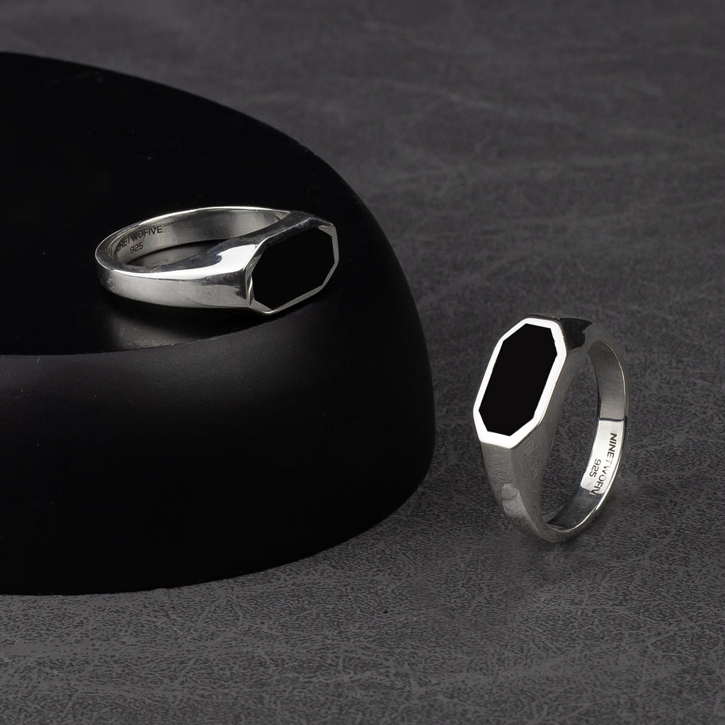 A silver signet ring with black onyx.