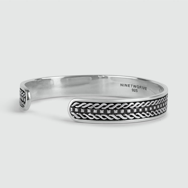 Close-up van de binnenzijde van de Fariq 925 sterling zilveren cuff armband met gevlochten design.
