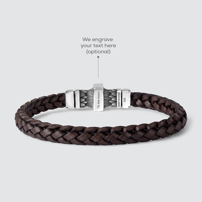 A dark brown braided leather bracelet with a silver-toned metal clasp, shown on a light gray background with an overlay text pointing to the clasp for personalization.