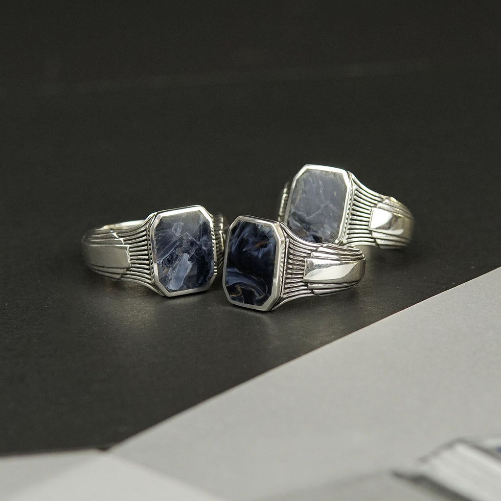 A pair of silver rings with a blue stone.