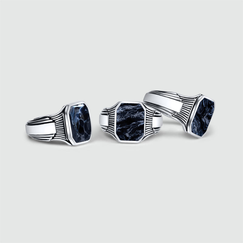 Drie Bariq-zegelringen van sterlingzilver voor heren, afgebeeld vanuit verschillende hoeken op een witte achtergrond.