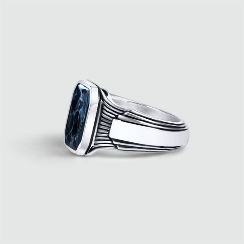 Zijaanzicht van de Bariq sterlingzilveren heren zegelring, met een blauwe steen van Ninetwofive, om het gegraveerde ontwerp te laten zien.