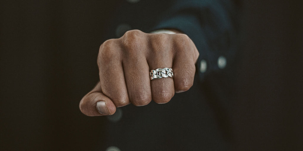 A hand holding a diamond ring.