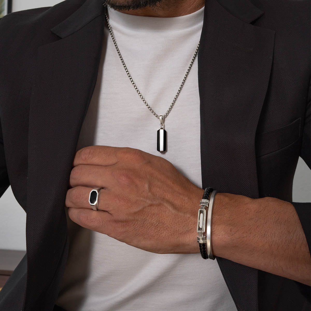 Man wearing samir sterling silver pendant, black onyx ring and leather bracelet from ninetwofive.