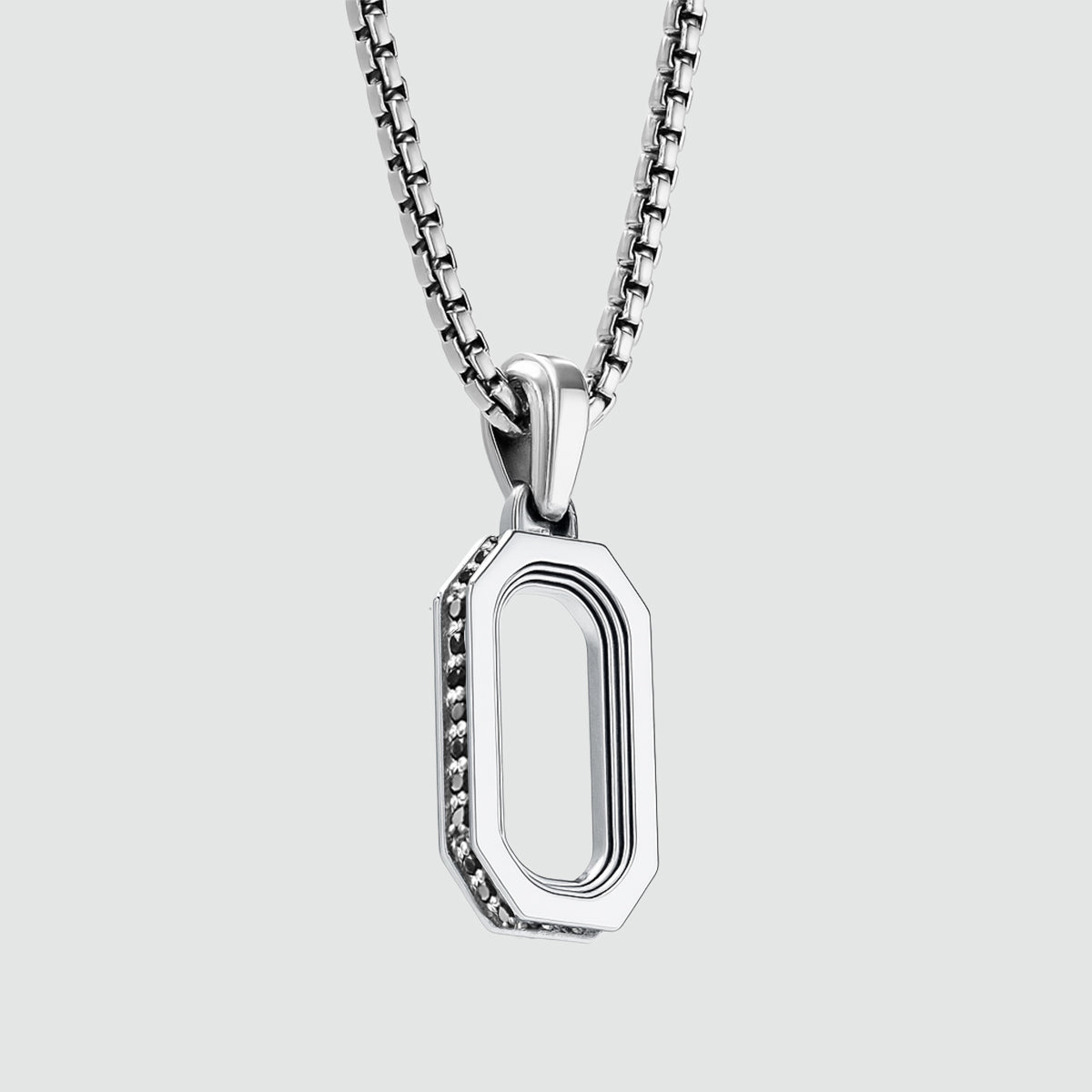 Zijdelingse detail van Durwas sterling zilveren herenhanger van Ninetwofive, met Amerikaans ontwerp van zwarte diamanten. 