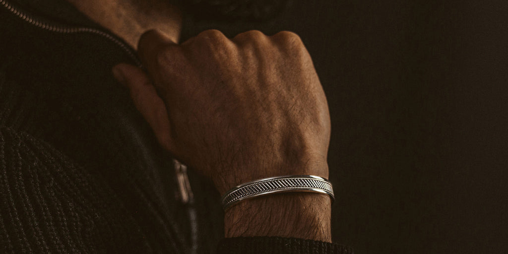 A man wearing a silver bracelet.