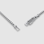 Gros plan sur une pièce d'argent boîte bracelet en chaîne avec fermoir sur fond gris clair