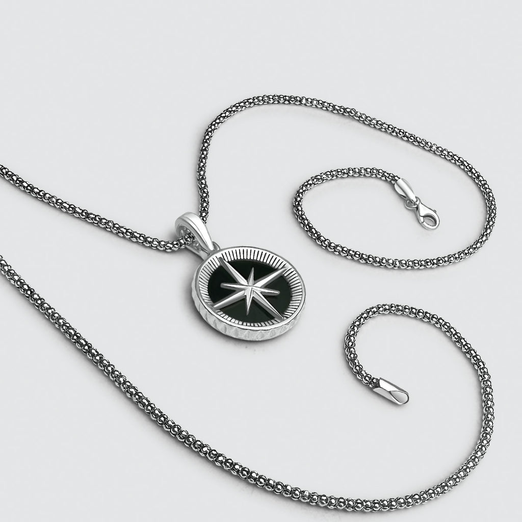 Een Safar - Sterling zilveren onyx kompas hanger met een zwarte ster aan een zilveren ketting voor mannen.
