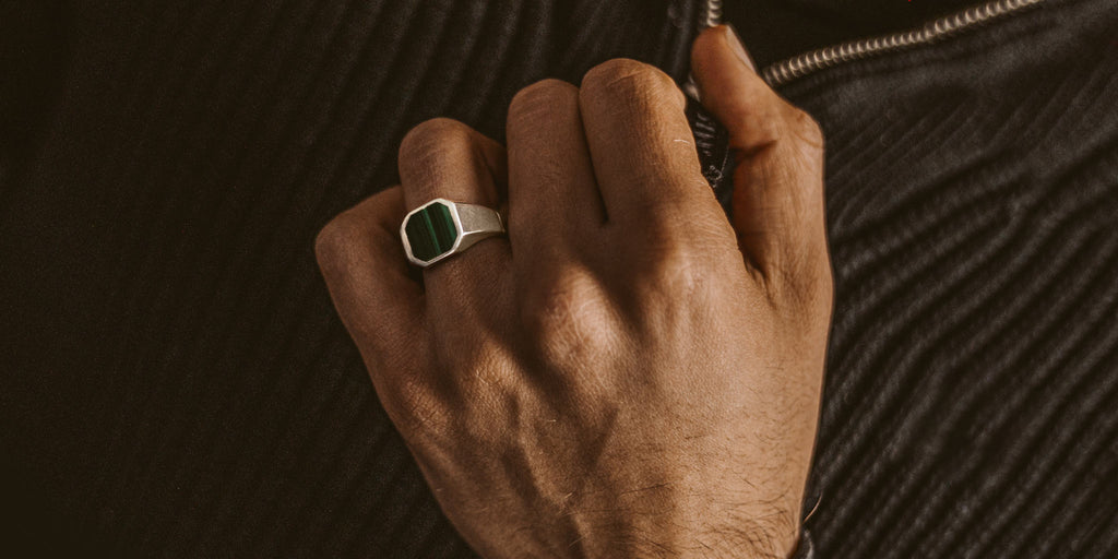 A man wearing an emerald ring.