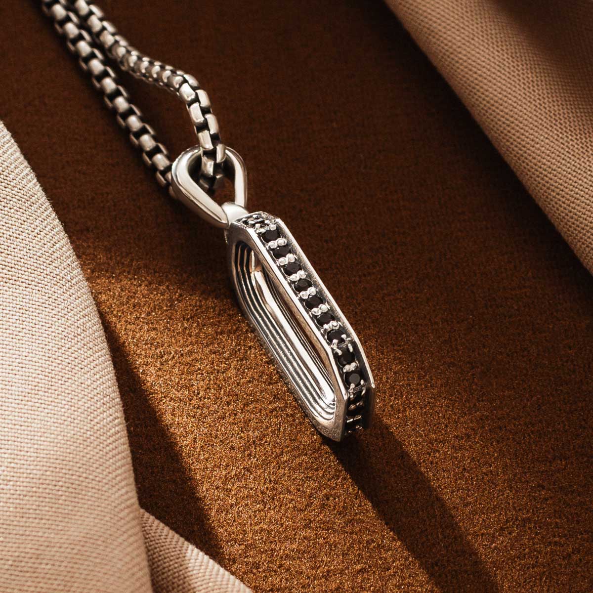 Détail latéral du pendentif en argent Durwās arch, montrant sa forme incurvée. Ninetwofive