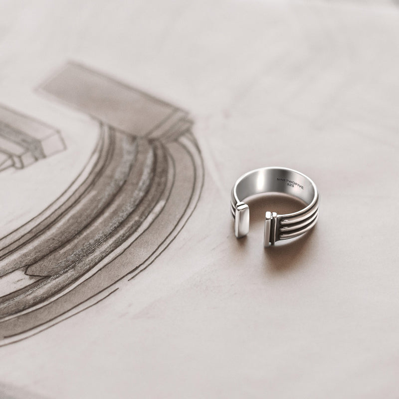 Ninetwofive Mateen Silber-Armreif und Herrenring liegen neben Design-Skizzen, die ihren oxidierten Look zeigen.