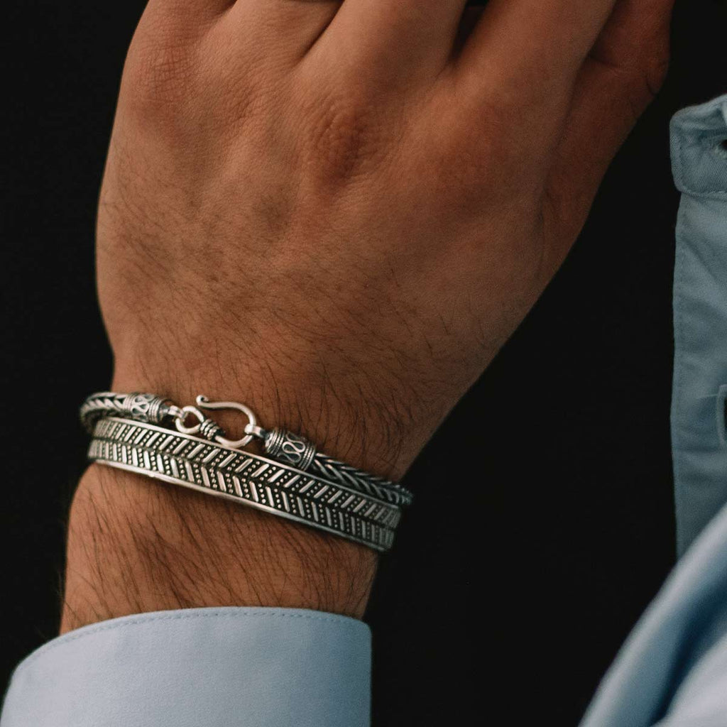 Ein Mann trägt ein silbernes Armband an seinem Handgelenk.