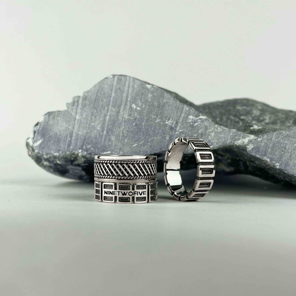 A pair of silver rings on a rock.