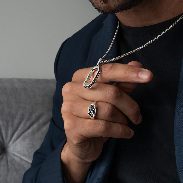 homme portant un collier en argent avec un pendentif et une bague assortie