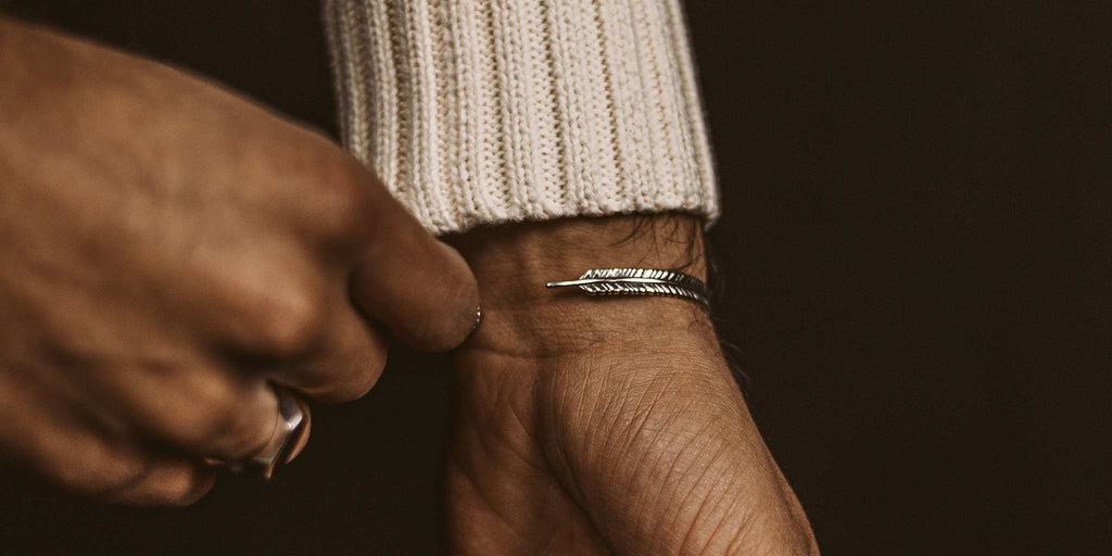 Ein Mann hält einen silbernen Ring in der Hand.