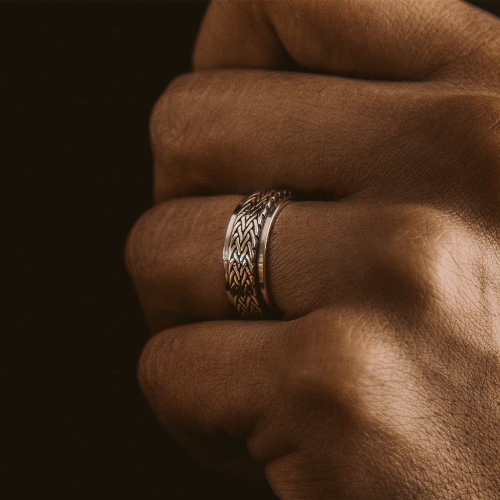 Die Hand eines Mannes ist mit einem silbernen Ring geschmückt.