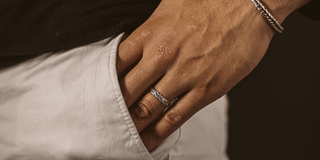 A man's hand with a ring on it.