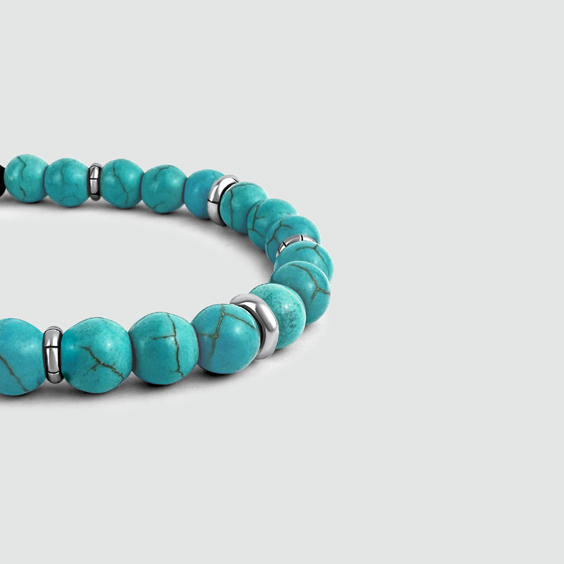 Close-up zijaanzicht van de Nuri sterling zilveren heren armband met turkoois van Ninetwofive op een wit oppervlak.