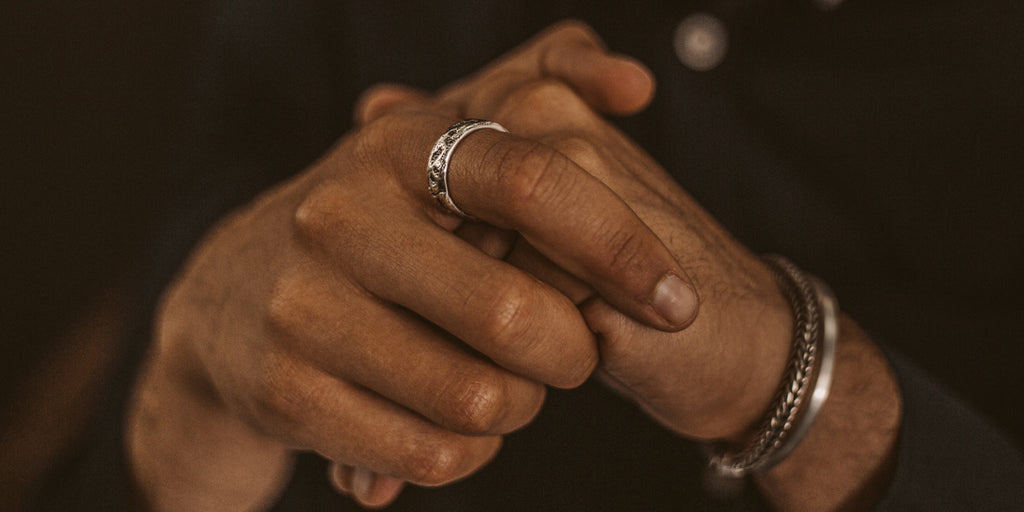 Die Hand eines Mannes mit einem Ring daran.