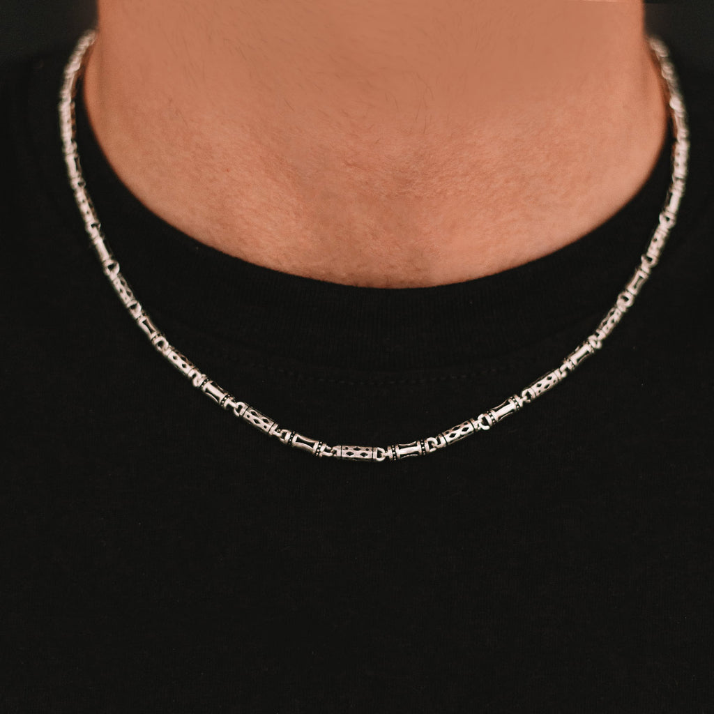 A man wearing a silver necklace.