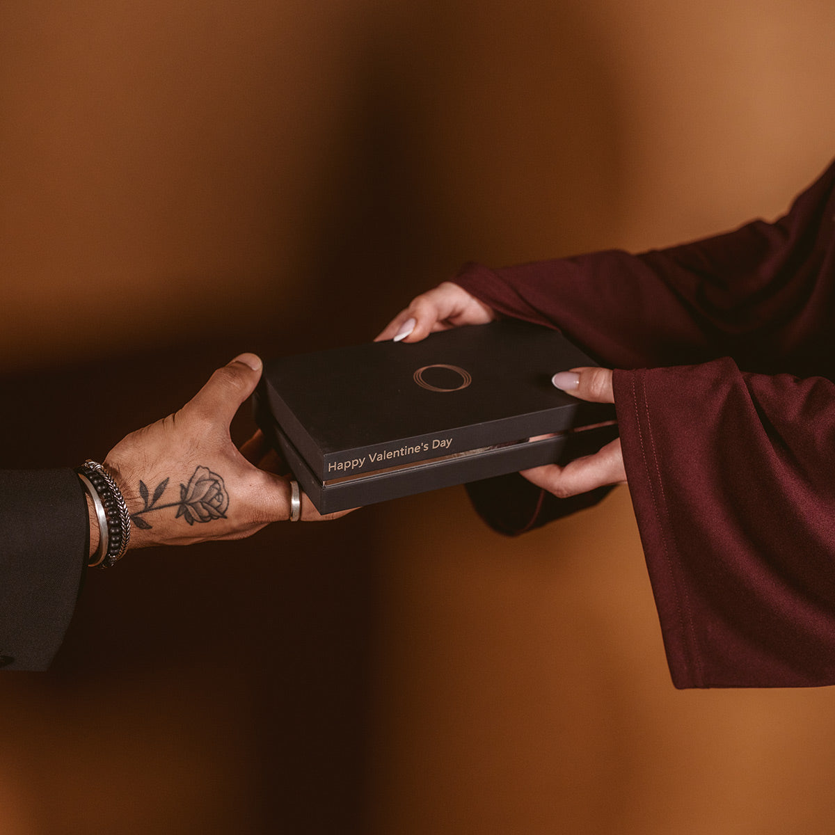 Un homme et une femme s'échangent un cadeau de Saint-Valentin sous forme de bijou boîte conçue par Ninetwofive.