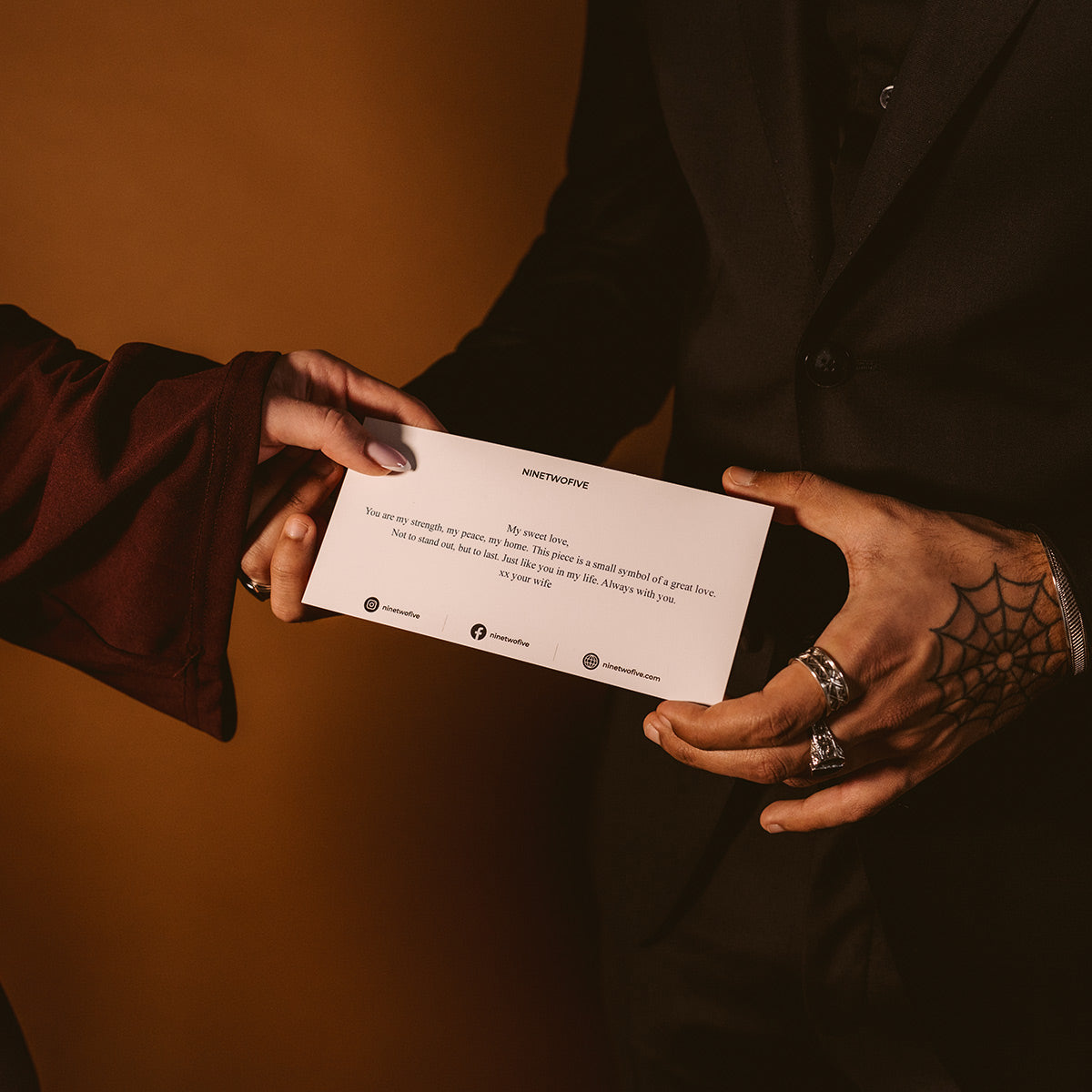 Un homme offre une carte de Saint-Valentin avec un bijou à une femme.