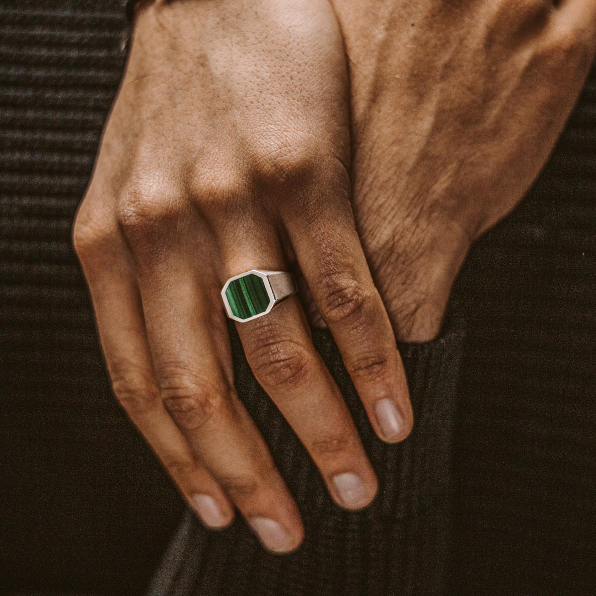 Un homme portant une chevalière Zaid en argent sterling en malachite de 13 mm avec une pierre verte frappante.
