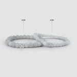 A pair of Abyad - White Beaded Bracelet 6mm bracelets with a 6mm silver tag.
