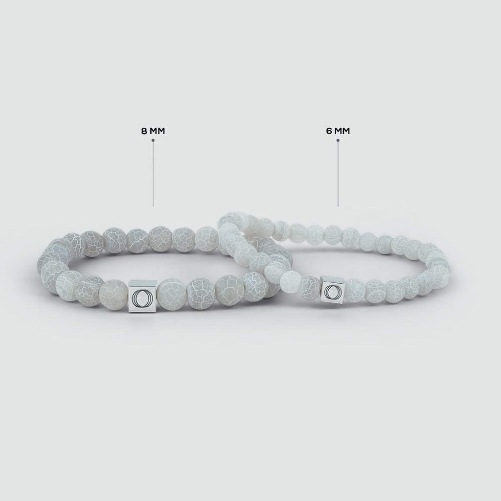 Une paire de bracelets Abyad - White Beaded Bracelet 6mm avec une étiquette en argent de 6mm.