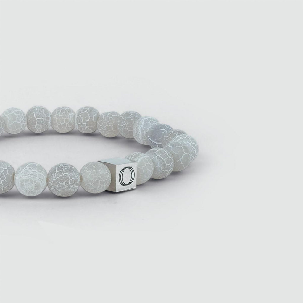 Abyad - White Beaded Bracelet 6mm with a silver letter o on it.