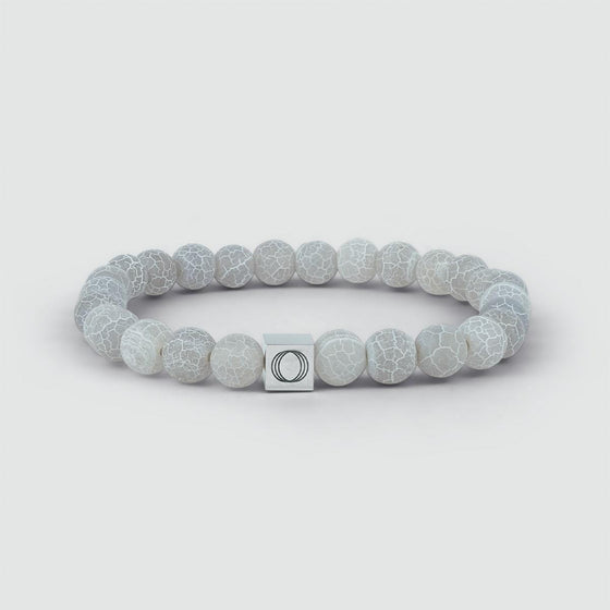 Vooraanzicht van de Abyad-armband voor heren, met de verweerde steen en het logo van de 'Ninetwofive' in het midden.