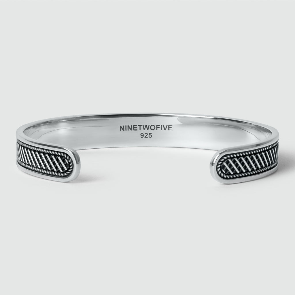 A Kaliq - Oxidized Sterling Silver Bangle 10mm with a black and white pattern, suitable for men and can be personalized or engraved.
