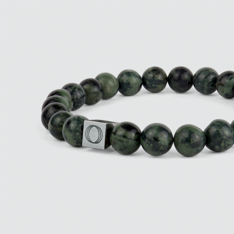 Close up side angle of the Aghdar mens green beaded bracelet, showing the stone and the Ninetwofive logo detail.