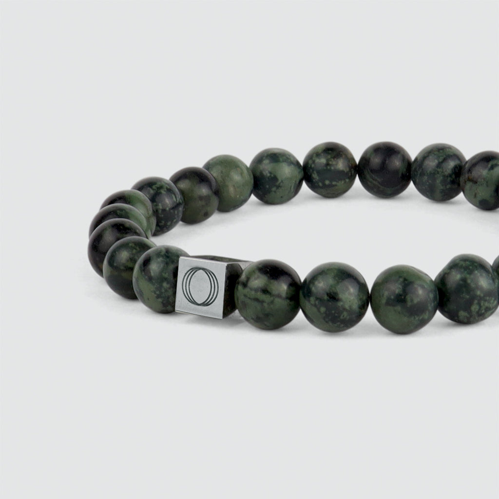 An Ahgdar - Green Beaded Bracelet 8mm with green jade beads and a silver clasp that features a weathering stone.
