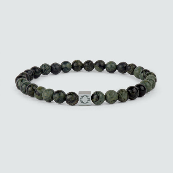 Front view of Ahgdar green beaded bracelet and showing engraved Ninetwofive logo.