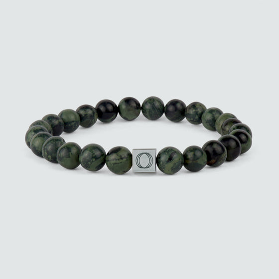 Front view of Ahgdar green beaded bracelet with a green jade bead and a silver charm, featuring a weathering stone.
