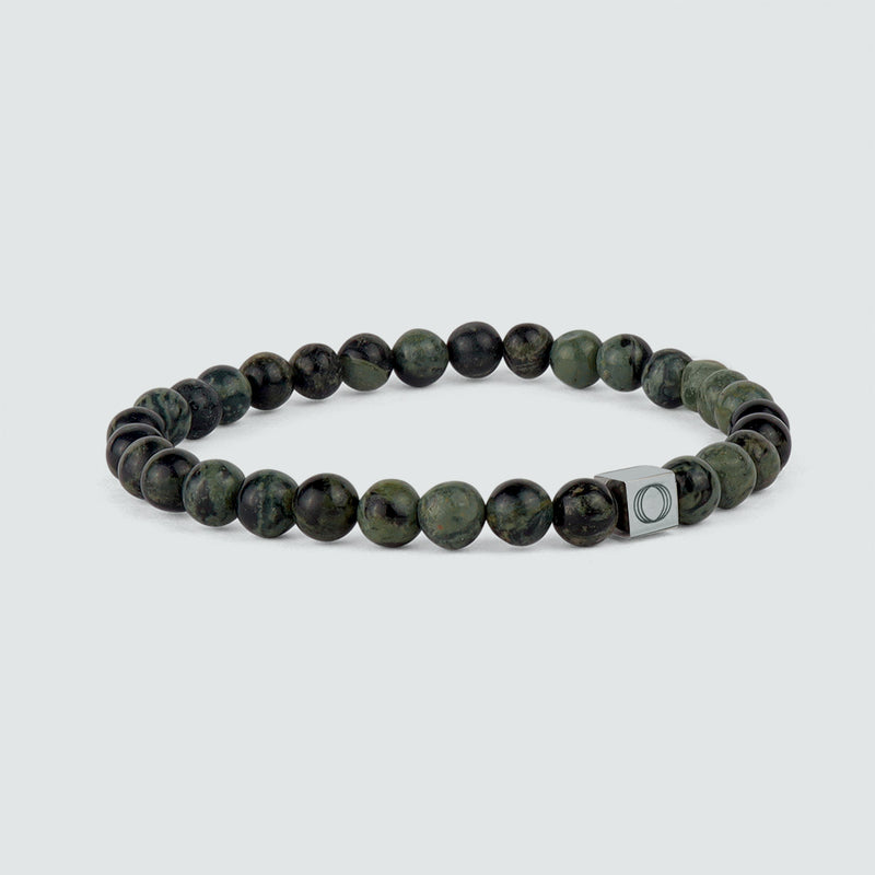 Side view of the Aghdar mens green beaded bracelet, showing the beads and the engraved Ninetwofive logo.