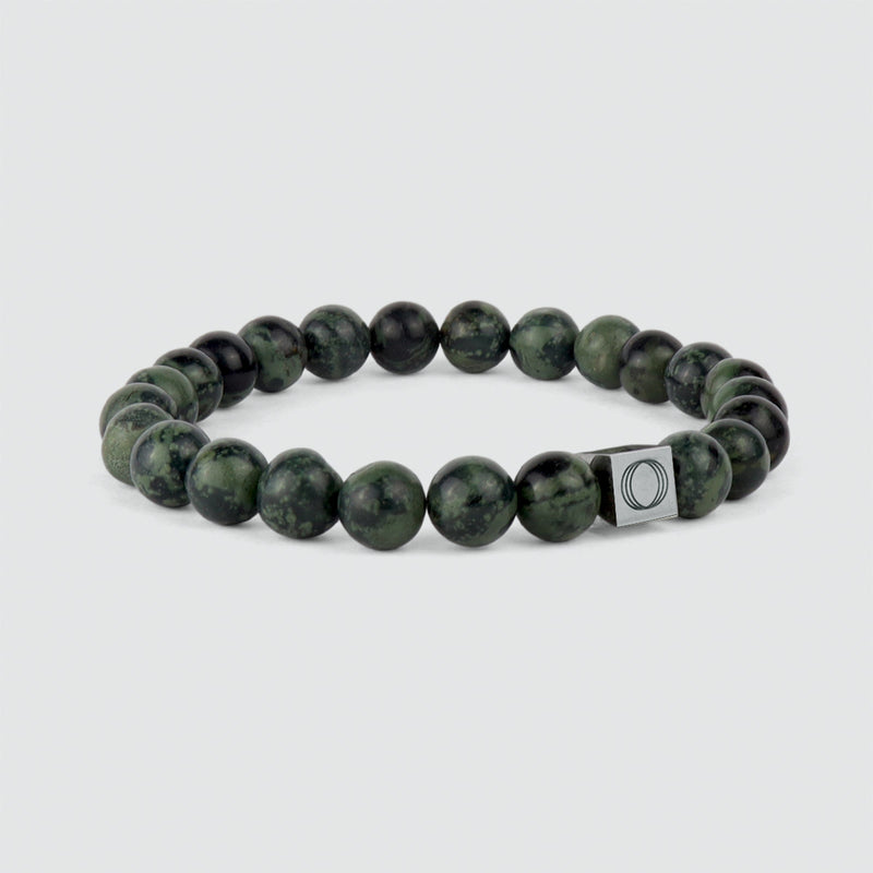 Angle view of the Aghdar mens green beaded bracelet, showing the beads and the engraved Ninetwofive logo.